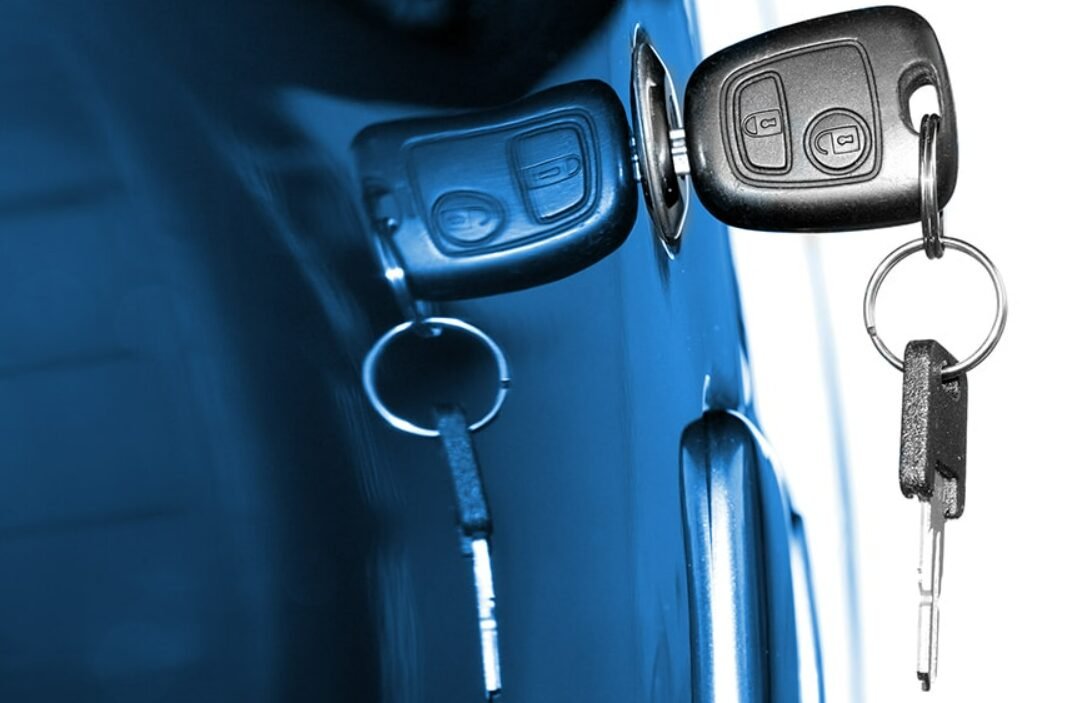 A professional locksmith from Blueline Locksmith, holding a freshly cut car key, ready to replace a customer's lost key, showcasing efficient car key replacement services.