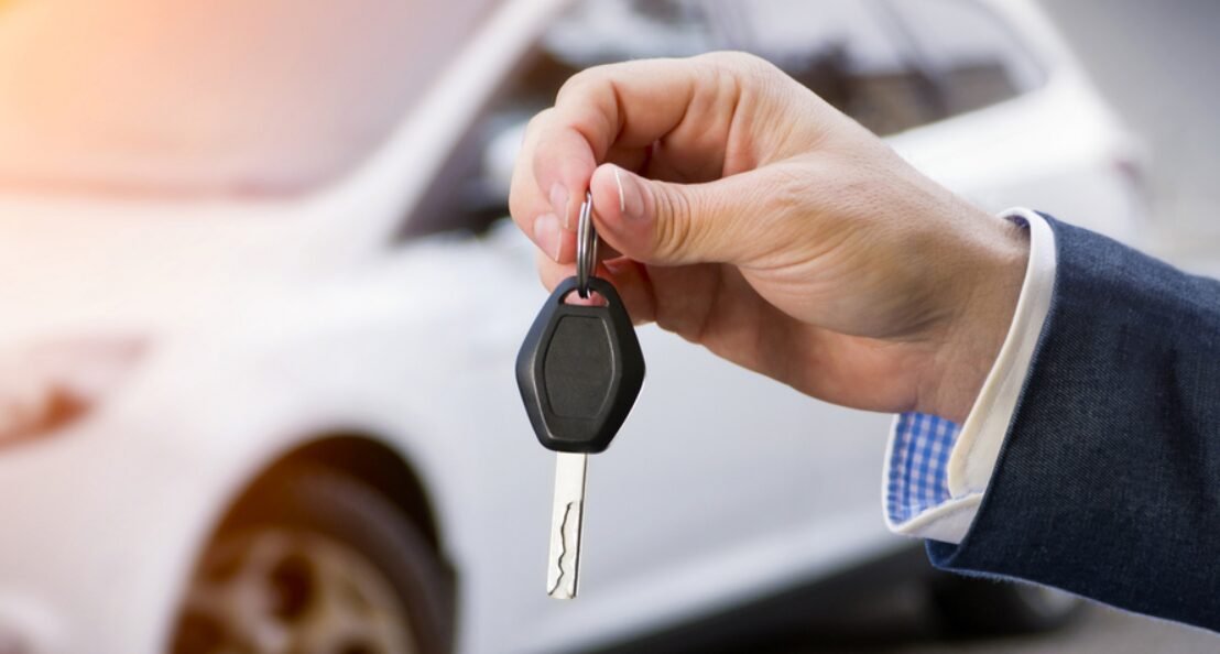 Close-up image of a professional locksmith holding a new car key replacement, showcasing Blueline Locksmith's expert car key services.